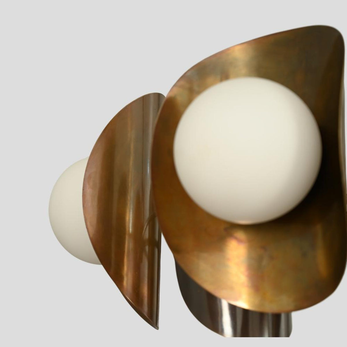 Detailed close-up of a brass chandelier shade with frosted globe bulb, industrial modern handcrafted ceiling light.