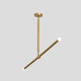 Close angled view of brass linear chandelier with minimalist rod form and bulb accents, handcrafted industrial ceiling lighting.