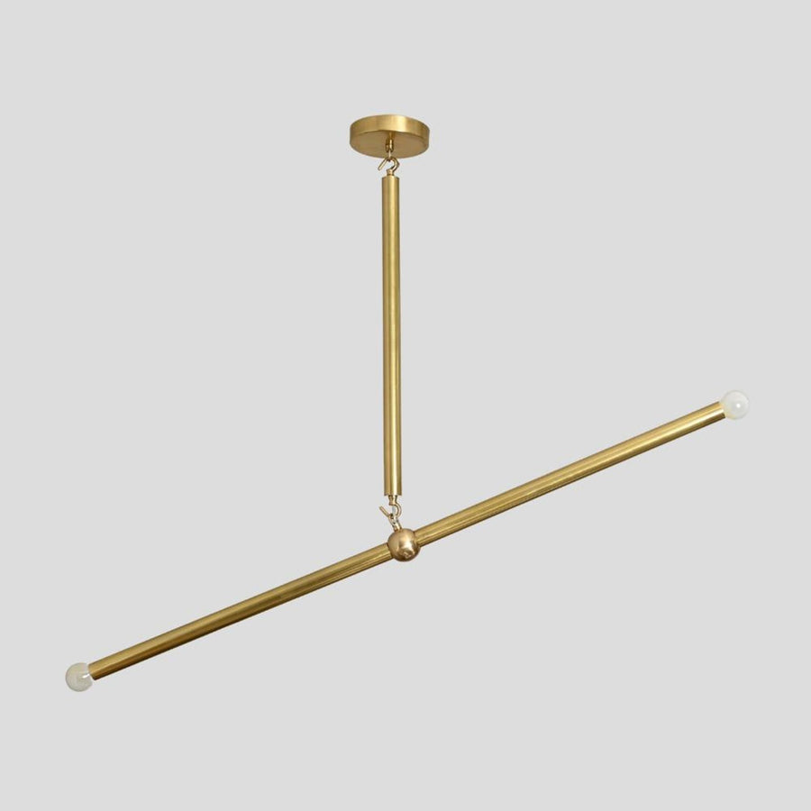 Handmade brass linear chandelier with minimalist rod design and bulbs at both ends, modern ceiling light by Brass Leaf Studio.