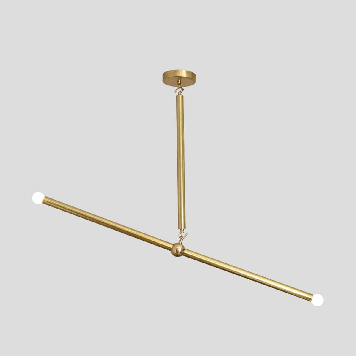 Side angle of handcrafted brass linear chandelier with slim rod design, featuring bulbs on both ends for sleek modern lighting.