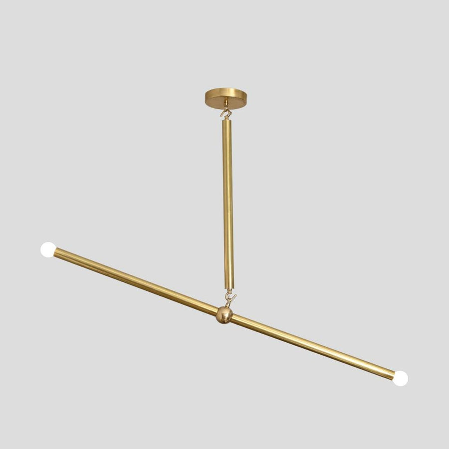 Handmade brass linear chandelier with minimalist rod design and bulbs at both ends, modern ceiling light by Brass Leaf Studio.