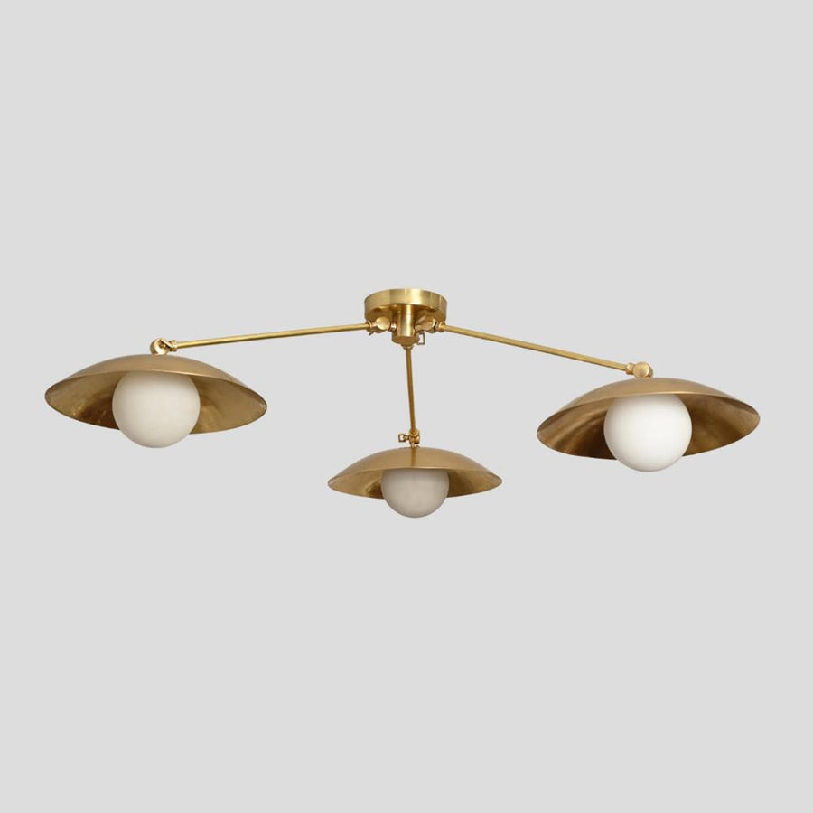 Handmade brass 3-light flushmount chandelier with wide bowl-shaped shades and white globes, modern industrial design view from side angle.