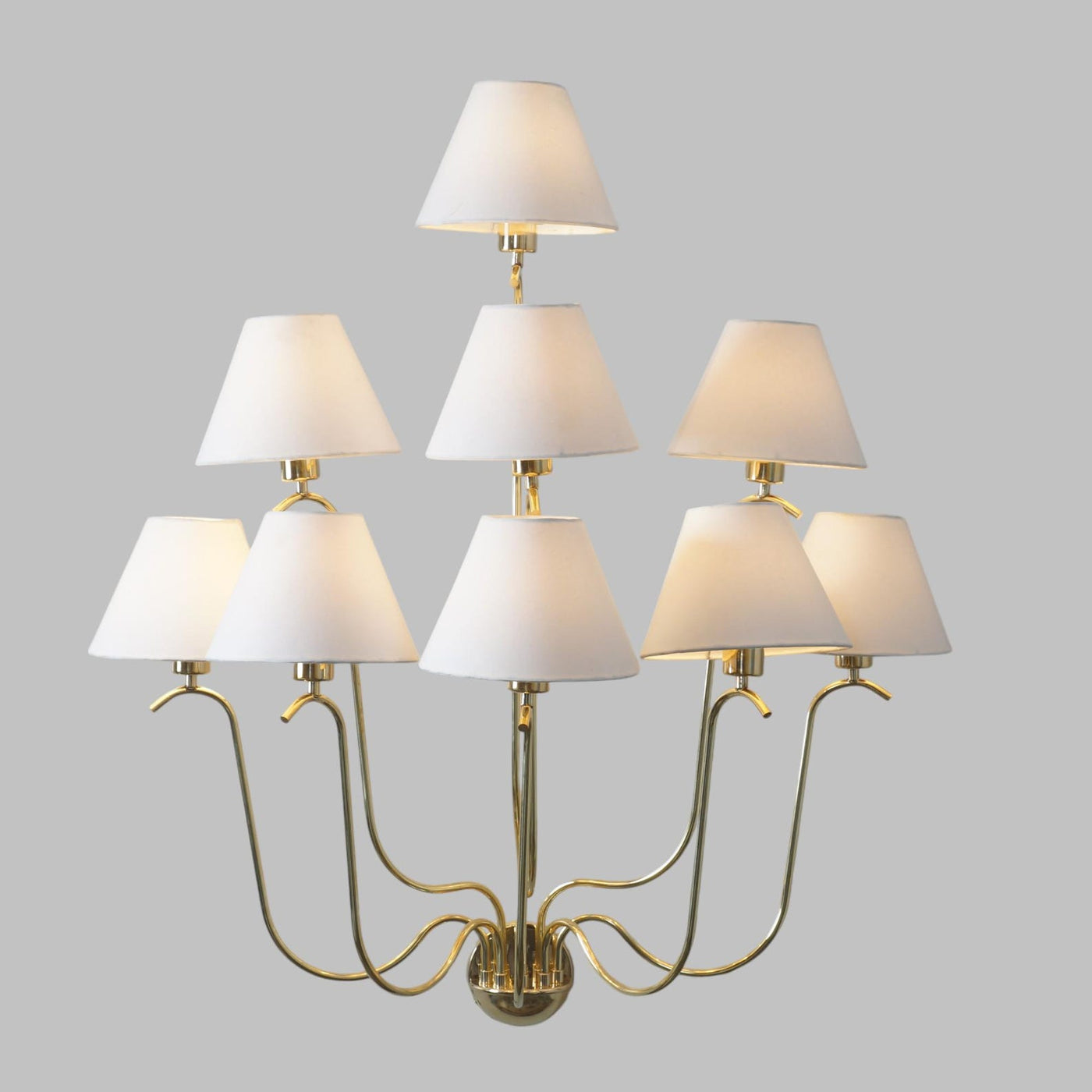 Elegant brass multi-arm chandelier with nine white fabric shades, handcrafted lighting fixture by Brass Leaf Studio.