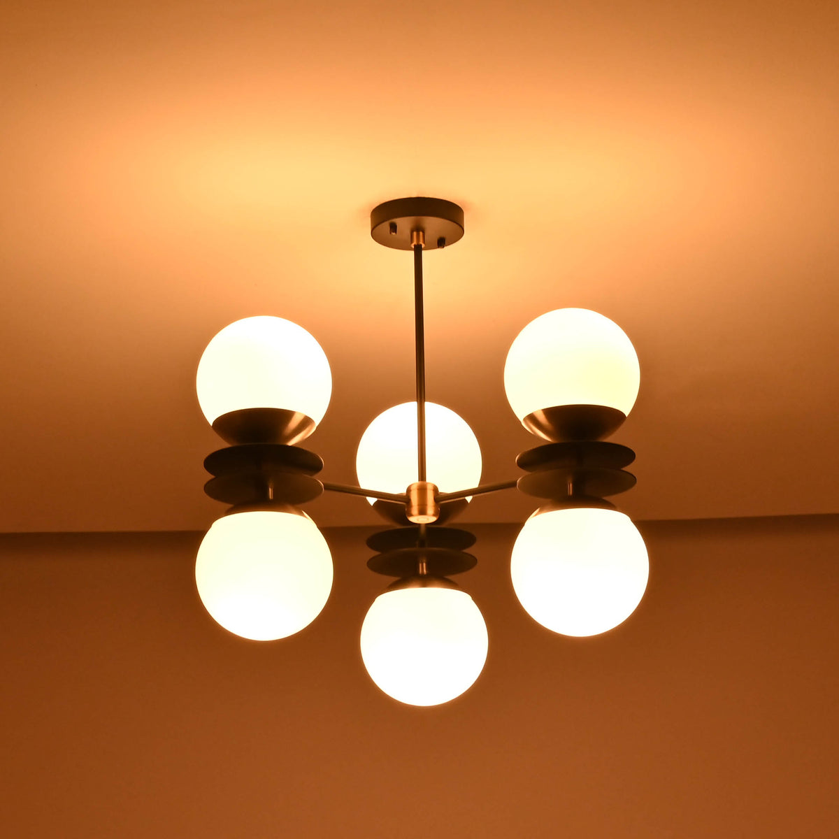 Six light brass chandelier with opal glass globes creating warm ambient glow in dark interior