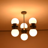 Six light brass chandelier with opal glass globes creating warm ambient glow in dark interior