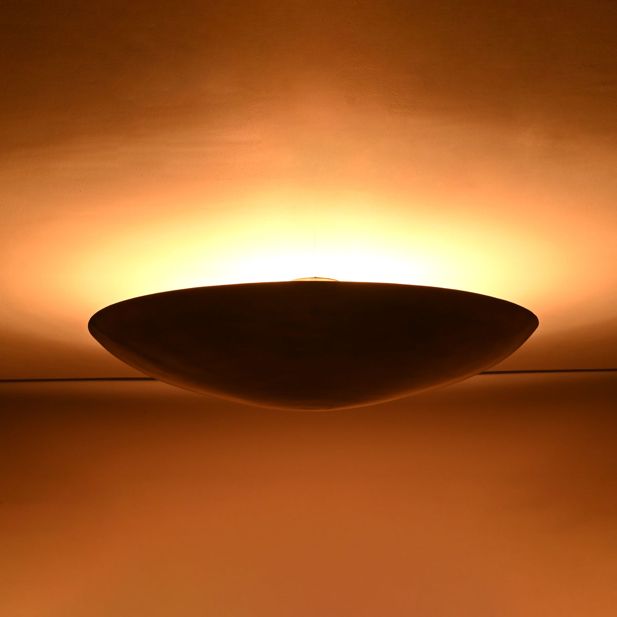 Brass patina halo ceiling light casting soft upward glow across the ceiling surface