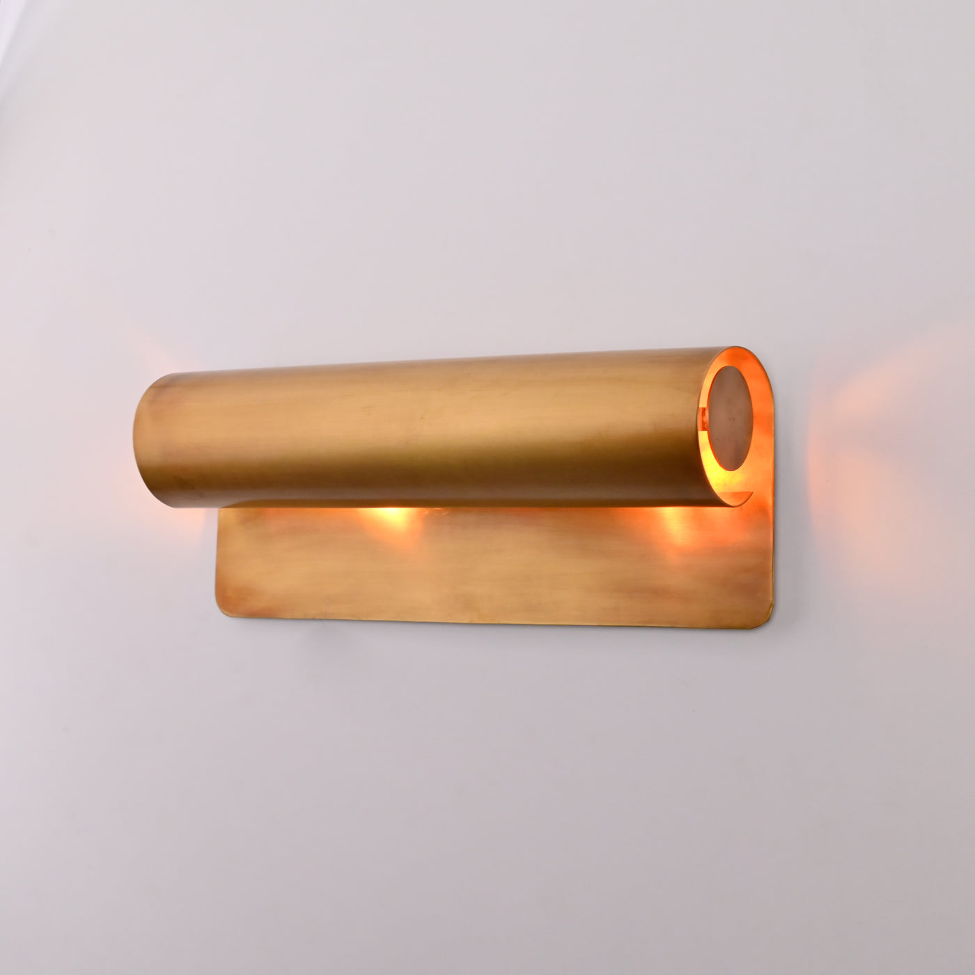 Brass Patina linear up down wall sconce shown above bedside table with warm ambient glow