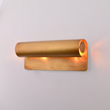 Brass Patina linear up down wall sconce shown above bedside table with warm ambient glow