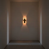 Brass patina rectangular wall light with slim vertical tube design and warm ambient illumination for hallway or bedroom walls