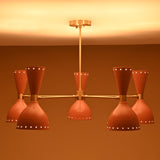 Soft light glowing from six peach brass shades of handmade chandelier