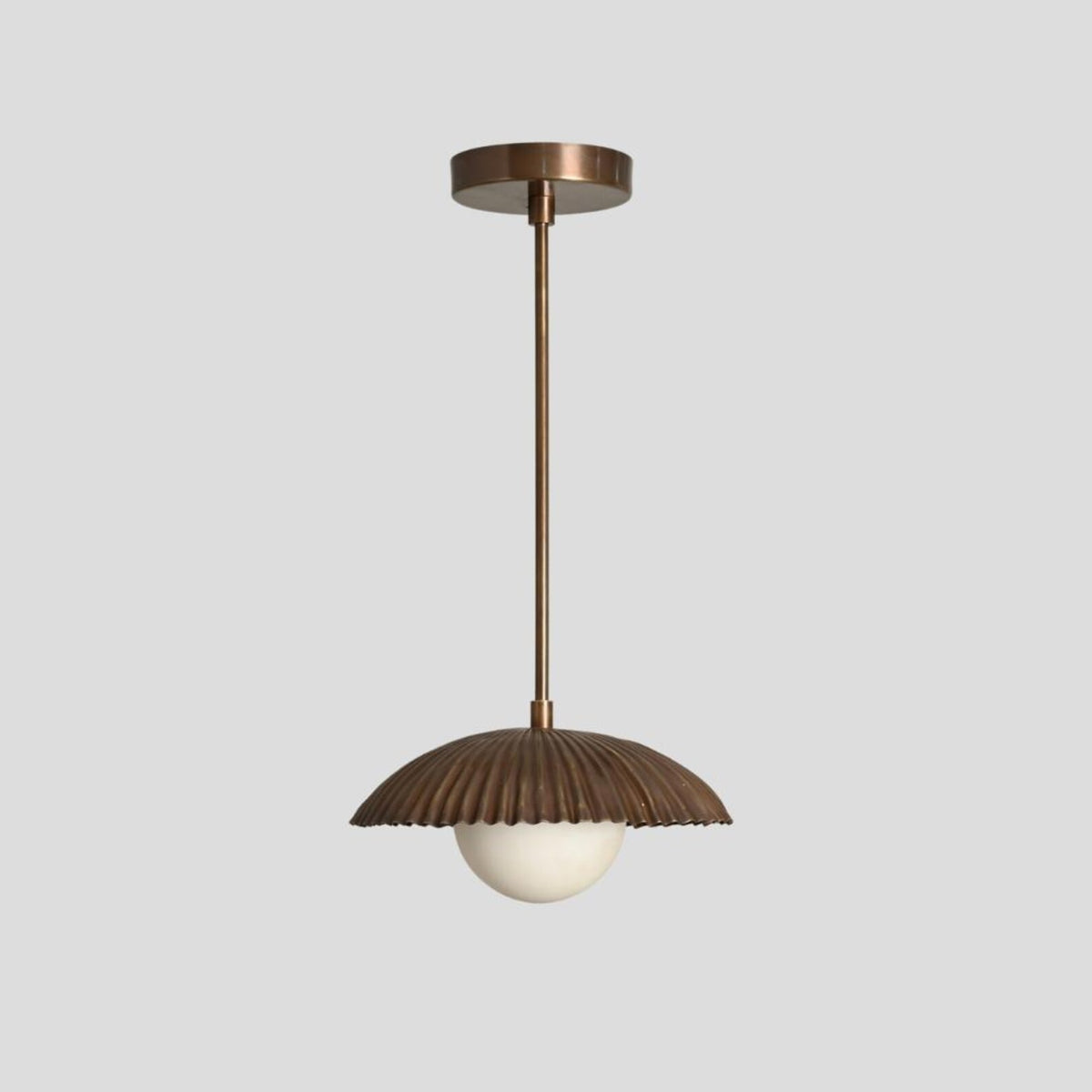 Industrial brass pendant lamp with ribbed dome shade and round opal glass globe, ideal for dining rooms, bedrooms, and cafes.