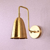 Handmade brass perforated wall sconce with curved arm and round backplate
