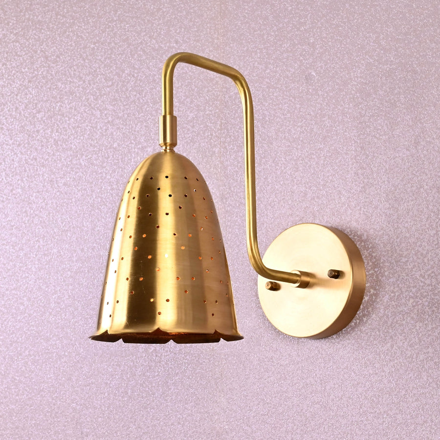 Handmade brass perforated wall sconce with curved arm and round backplate