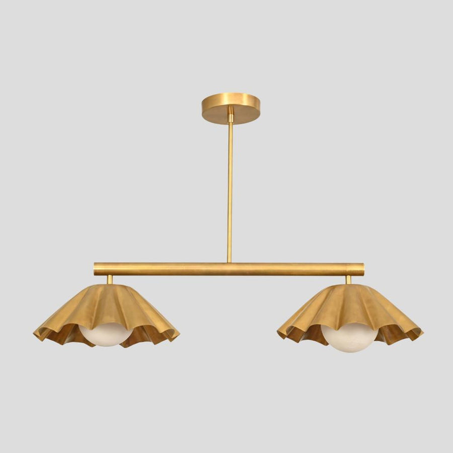 Brass chandelier with two ruffle-edged shades and globe lights, handcrafted pendant for dining rooms and boutique interiors.