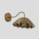 Brass wall sconce with ruffle shade and curved arm, handmade artistic light fixture angled view