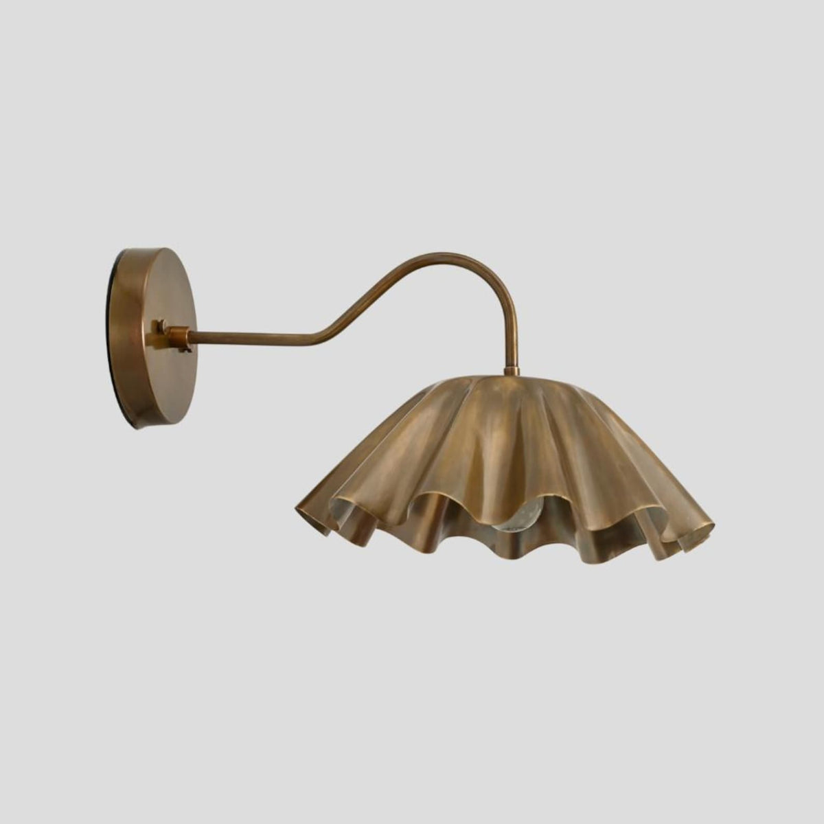 Artistic brass wall sconce featuring ruffled shade and curved arm, modern handcrafted wall light profile view