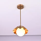 Angled view of handmade brass ruffled pendant lamp with frosted globe bulb