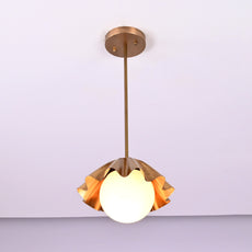 Angled view of handmade brass ruffled pendant lamp with frosted globe bulb