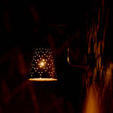 rass perforated sconce light creating starburst glow effect on wall in dark