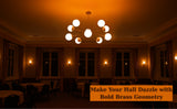 Illuminated brass Sputnik chandelier with opal glass globes in a dark ballroom with warm ambient lighting.