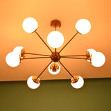 Brass Sputnik chandelier bottom view showing even light glow from opal glass globes against a warm background.