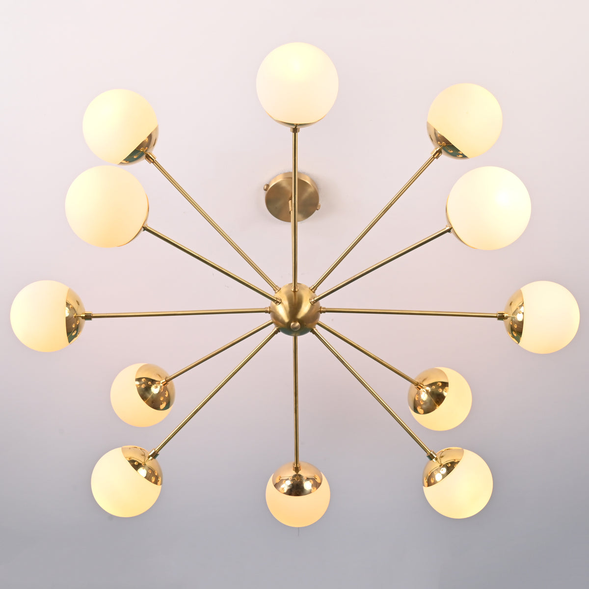 Bottom view of brass sputnik chandelier showing radial arms and evenly spaced opal glass globes