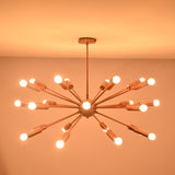 Brass sputnik chandelier glowing warmly in dark room creating dramatic ambient ceiling lighting.
