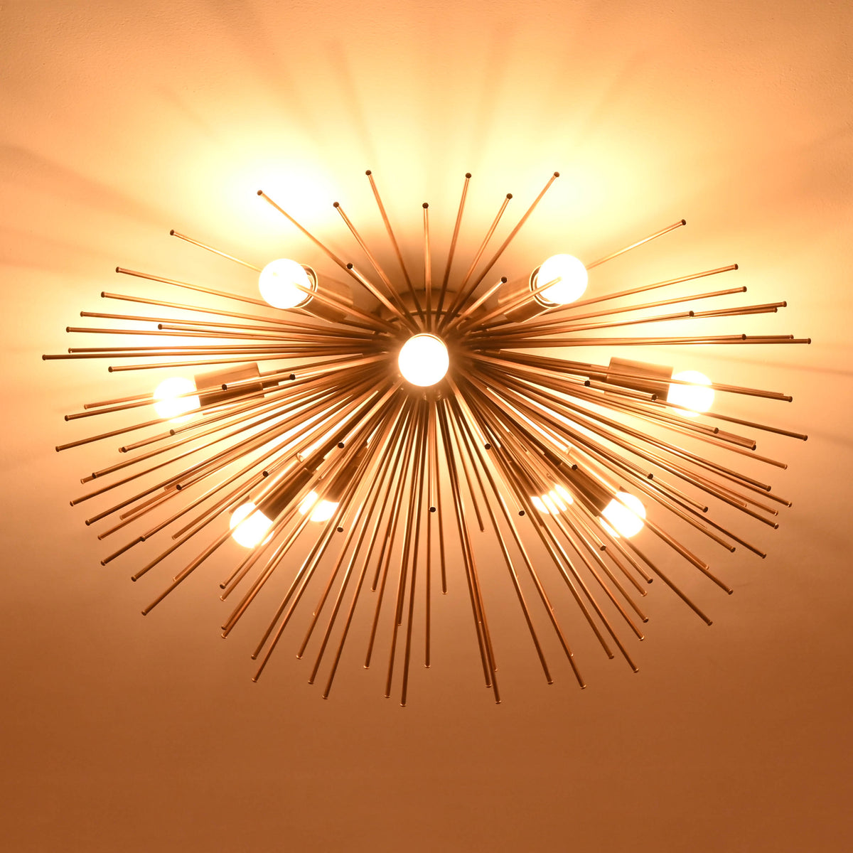 Brass starburst chandelier showcasing central light focus and sculptural rod arrangement