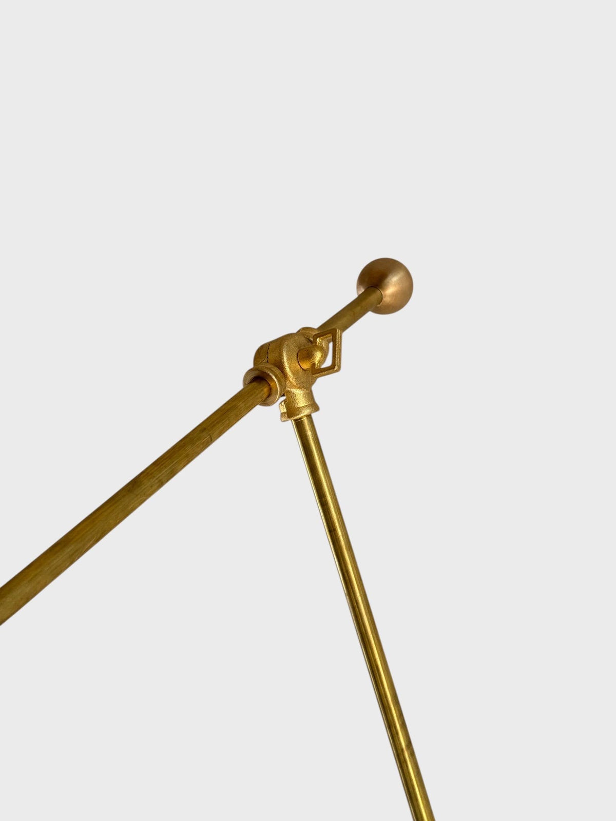 Close-up of brass swing arm joint and hardware detailing on adjustable wall sconce