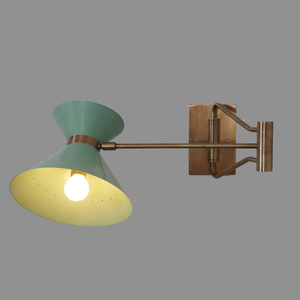 Adjustable brass swing arm wall lamp with sculptural cone shade, shown illuminated, handcrafted in solid brass by Brass Leaf Studio.
