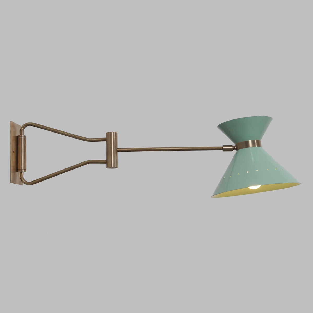 Side profile of brass swing arm wall light with long adjustable reach and minimalist cone shade, ideal for reading and task lighting.