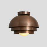 Front view of tiered brass dome flush mount chandelier – handmade 1-light ceiling light with warm ambient glow