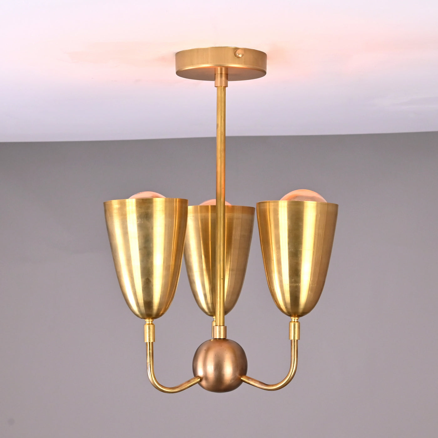Main view of brass 3-light flushmount chandelier with sculpted cup shades and minimalist brass frame.