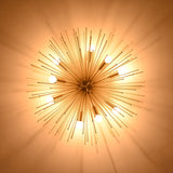 Bottom view of illuminated brass urchin ceiling light creating soft radial shadows on the ceiling.