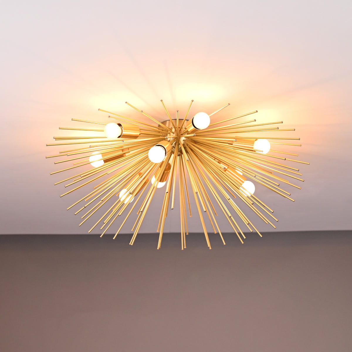 Close-up of brass urchin chandelier with soft warm lighting highlighting the intricate brass rod arrangement.