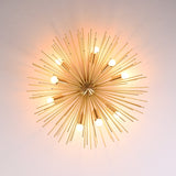 Bottom angle view of brass urchin flushmount chandelier showing symmetrical spokes and glowing bulbs.