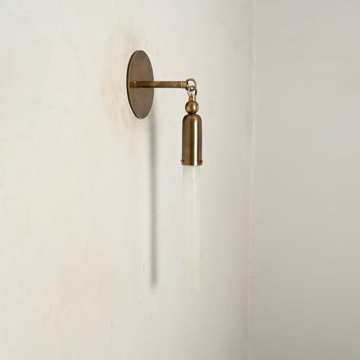 Handmade brass wall sconce with cylindrical tube shade, minimalist modern lighting fixture left side view