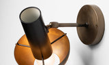 Angled detail of modern brass wall lamp showcasing bowl shade, inner glow, and precision-crafted brass hardware.