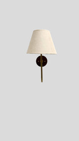 Front view of minimalist brass wall lamp with beige shade and wooden backplate, handcrafted by Brass Leaf Studio.