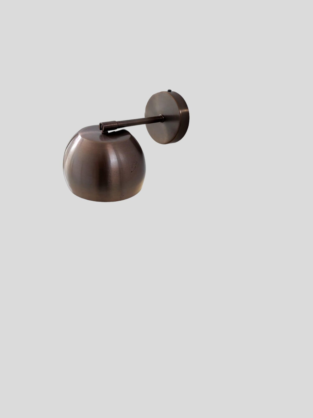 Top view of antique patina brass wall light showing adjustable arm and dome shade design