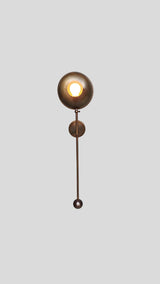 Bottom view of solid brass wall light sconce with glowing bowl shade
