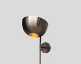 Close-up of brass wall light sconce bowl shade highlighting brushed finish