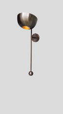 Side angle of handcrafted brass wall light with bowl shade and minimalist rod design