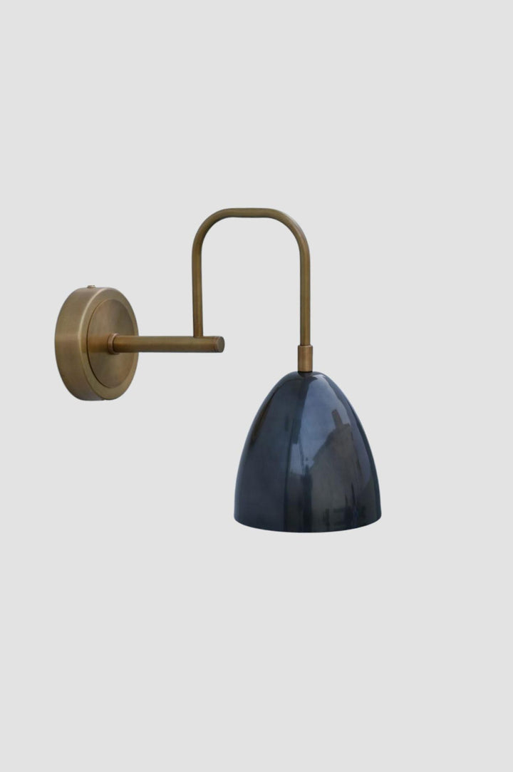 Angled view of brass wall sconce with curved arm and blue shade, crafted in solid brass for modern interiors
