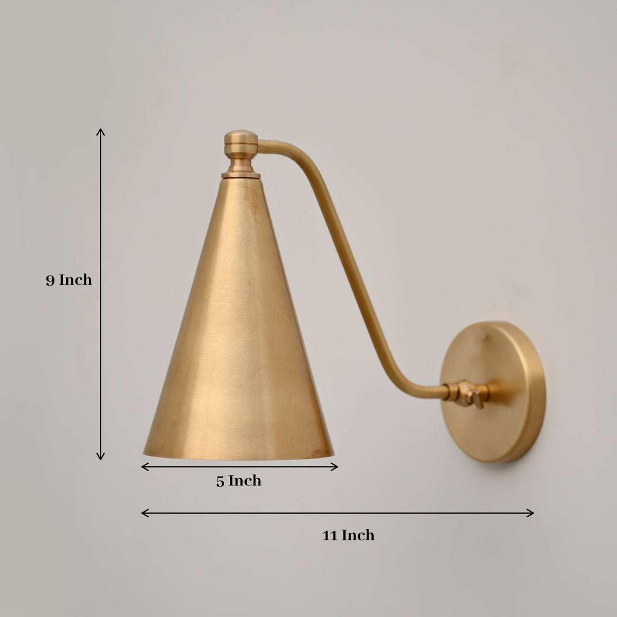 Brass wall sconce showing 9-inch height, 5-inch diameter, and 11-inch depth, featuring a sleek conical shade and solid brass finish.
