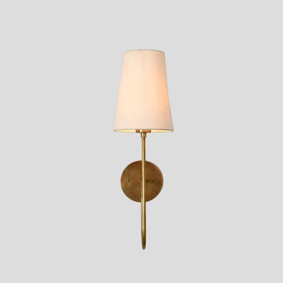 Contemporary brass wall sconce with tall tapered fabric shade and brass base, handcrafted by Brass Leaf Studio.