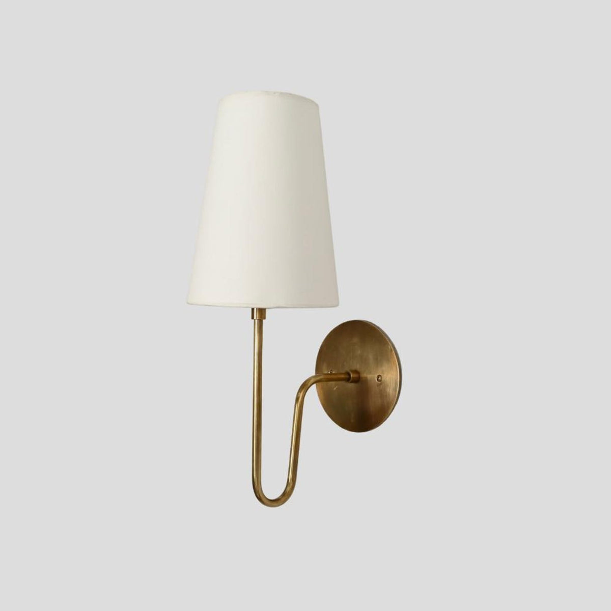 Solid brass wall sconce with fabric lampshade, right-side angle showing elegant minimalist design