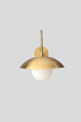 Center front view of brass wall sconce with dome shade and frosted glass globe bulb