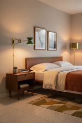 Brass wall sconce with green enamel shade, rectangular backplate, and extended adjustable arm