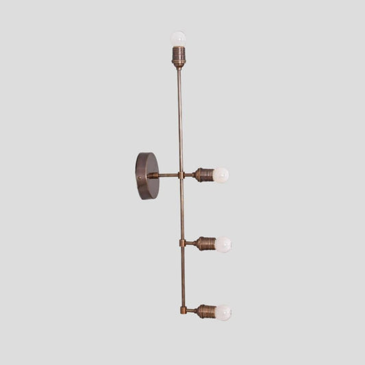 Handmade brass wall sconce with vertical linear design and exposed bulb holders, crafted by Brass Leaf Studio for modern and industrial interiors.